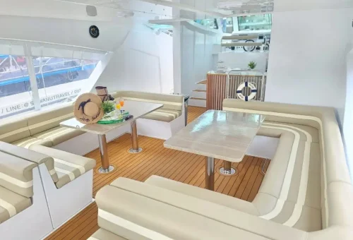 Spacious luxury yacht interior with modern lounge seating and dining area on Phang Nga Bay Sunset Serenity Cruise by Phuket Travel Store.