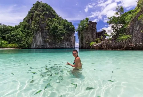 Traveler snorkeling with tropical fish in Hong Lagoon, Krabi.
