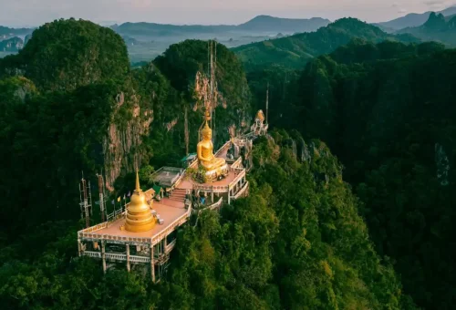 Tiger Cave Temple Krabi – panoramic view with golden Buddha statue on the mountain top.