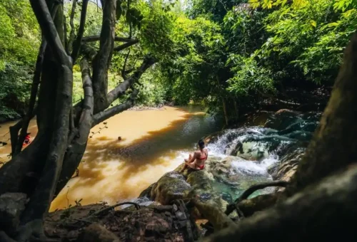 Tourist sitting at Krabi jungle hot spring with natural stream.