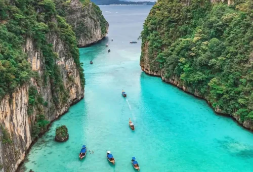 Boats cruising into Pileh Lagoon with emerald green water