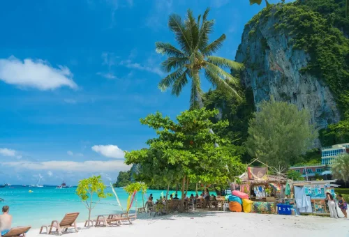 Beach scene at Phi Phi Don with palm trees, loungers, and turquoise sea