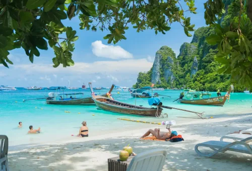 Longtail boats anchored at the beach of Phi Phi Islands with turquoise water