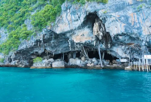 Entrance of Viking Cave with rugged cliffs and turquoise sea