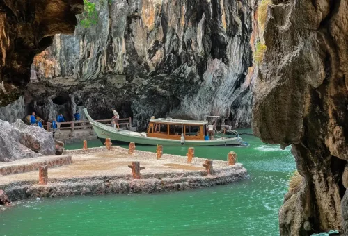Longtail boat at cave pier with turquoise water in Phang Nga Bay
