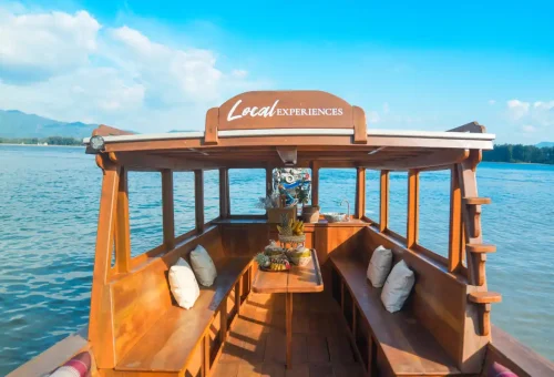 Inside traditional wooden longtail boat with tropical fruit setup