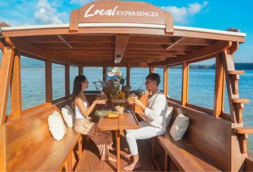 Couple enjoying tropical drinks inside private longtail boat