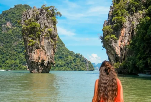 Woman standing before iconic limestone rock at James Bond Island