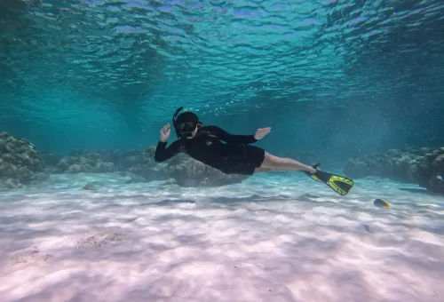 Woman snorkeling over white sandy seabed at Raya Yai Island