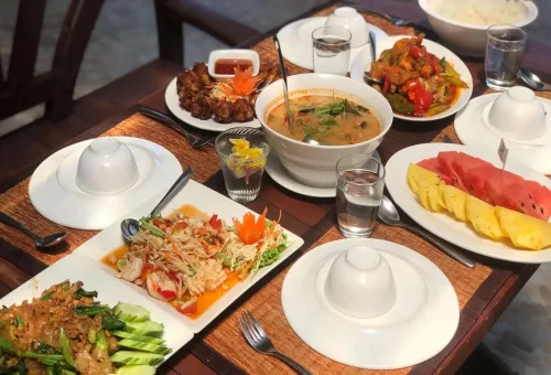 Authentic Thai lunch with tom yum soup, papaya salad, fried chicken, and tropical fruits served on Raya Island by Phuket Travel Store
