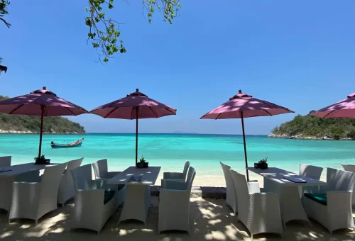 Beachfront restaurant with pink umbrellas and turquoise sea view at Raya Yai Island, Phuket Travel Store day tour stop