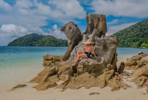 Woman relaxing on rock formation with sea view at Surin Islands Thailand