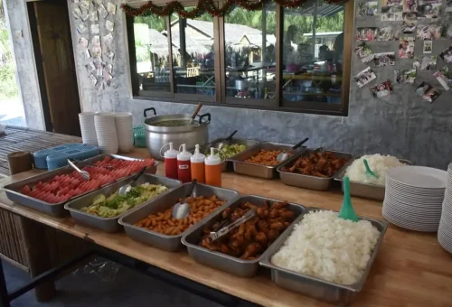 Buffet table with Thai food, rice, fruit, and drinks served after Phuket Elephant Care Park tour.
