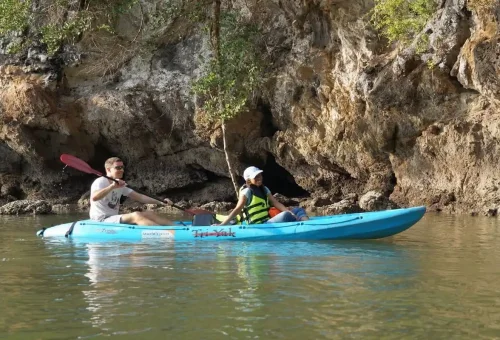 Man and woman kayaking close to rocky cliffs at Ao Thalane Krabi