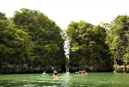 Kayakers paddling between limestone cliffs at Ao Thalane Krabi Thailand