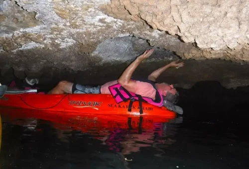 Tourist exploring a limestone cave by kayak at Ao Thalane Krabi Thailand