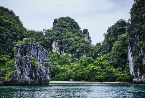 Green cliffs and tropical forest surrounding Koh Hong’s beach in Krabi – eco adventure destination.