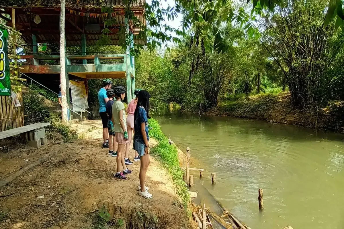 Cyclists enjoying the lush trails of Krabi near Huay Tho Waterfall on a guided eco-cycling tour.