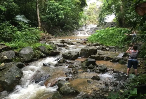 Cyclists exploring rocky river paths near Huay Tho Waterfall in Krabi.