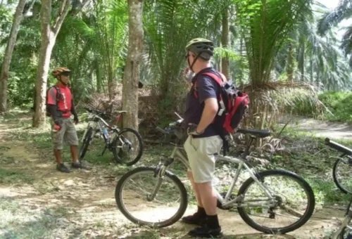 Traveler taking a photo of Huay Tho Waterfall after cycling tour.