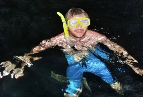 Tourist snorkeling at night among glowing plankton during the Krabi 7 Islands Tour.