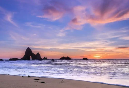 Colorful evening sky over the Andaman Sea with rock formations silhouetted by sunset.
