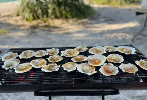Fresh seafood grilling over charcoal on the beach during the Krabi Sunset BBQ Tour.