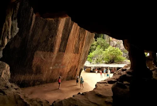 Tourists photographing prehistoric art inside a massive limestone cave on the James Bond Discovery tour.