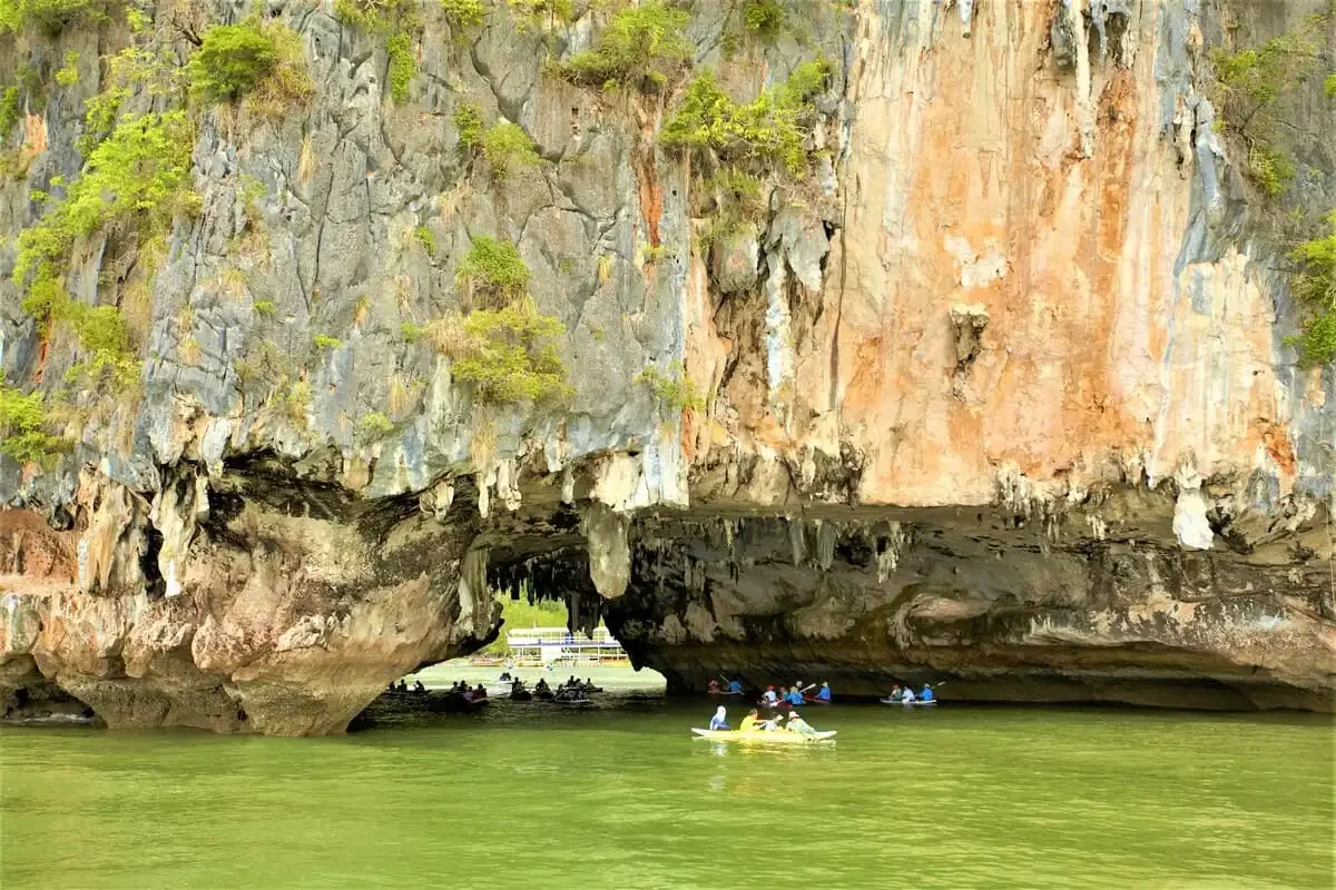 Limestone cave entrance with kayaks exploring underneath during the James Bond Discovery Canoeing Tour.