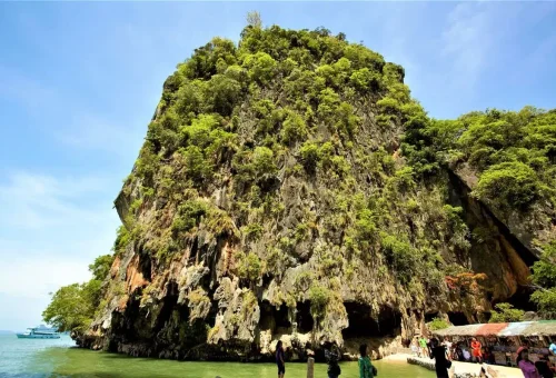 Tourists exploring the limestone cliffs and small caves at James Bond Island.