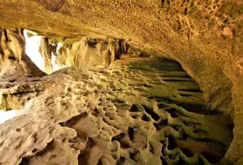 Inside view of Tham Lod Cave showing natural rock patterns and ancient stone formations.