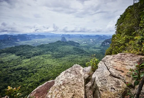 Natural stone viewpoint on Dragon Crest trail overlooking Krabi’s green landscape.