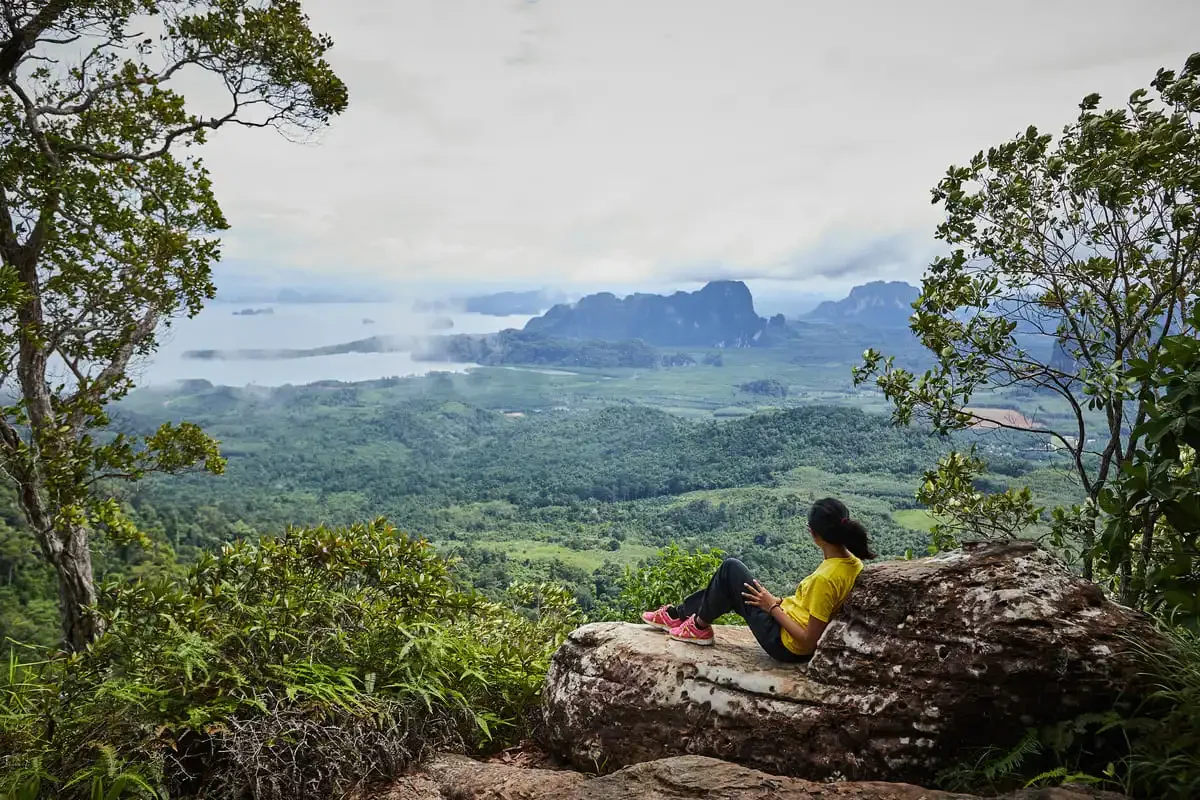 Relaxing on a rock viewpoint at Dragon Crest Mountain with misty morning view.