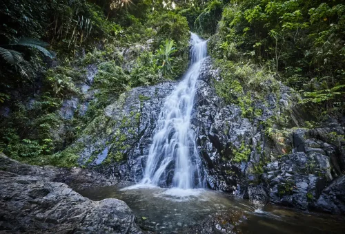 Huay Tho Waterfall cascading down rocks into a natural pool in Krabi.