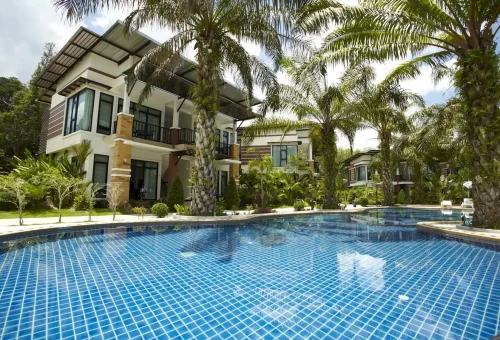 Tropical resort with swimming pool and palm trees in Krabi, Thailand.