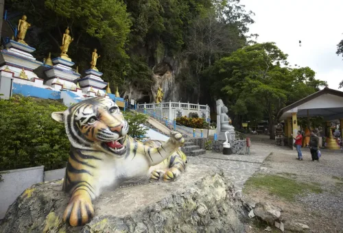 Tiger statue and Buddha images at the entrance of Tiger Cave Temple in Krabi.