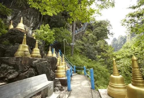 Golden pagodas along the forest stairway leading to Tiger Cave Temple in Krabi.