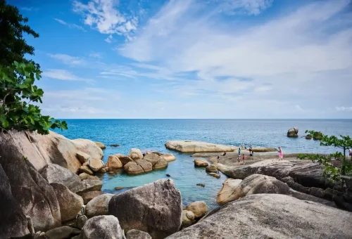 Tourists exploring Hin Ta and Hin Yai Rocks by the sea on Koh Samui Island.