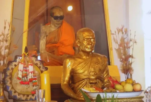 Preserved monk with sunglasses dressed in orange robes at Wat Khunaram, Koh Samui.