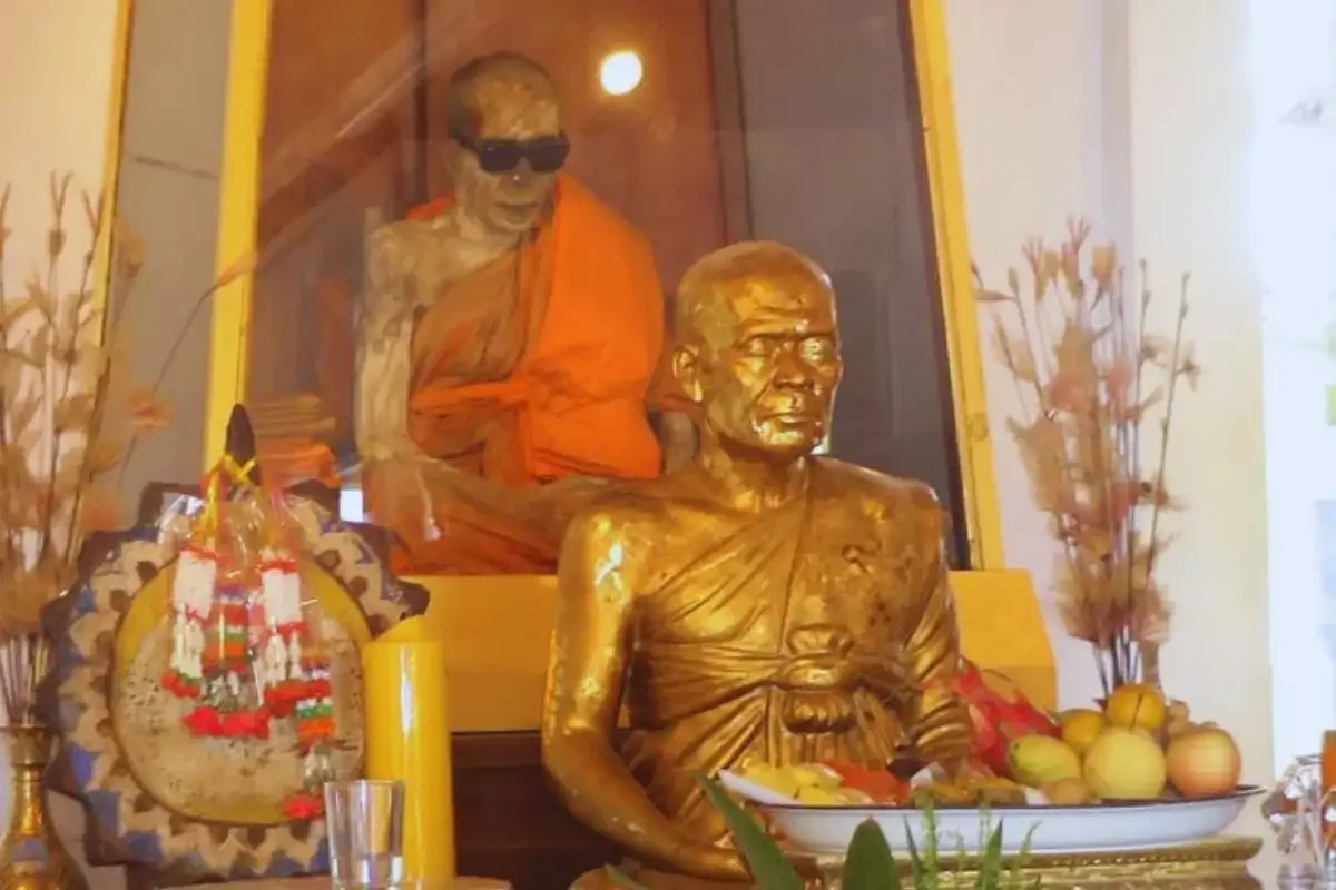 Preserved monk with sunglasses dressed in orange robes at Wat Khunaram, Koh Samui.