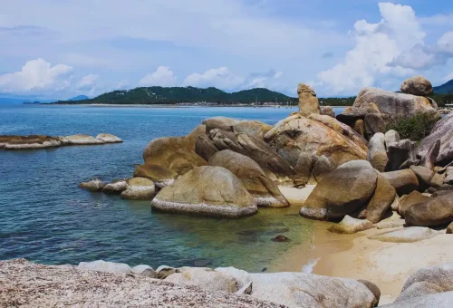 Hin Ta and Hin Yai Rocks along Koh Samui’s coastline with turquoise sea and mountain backdrop.