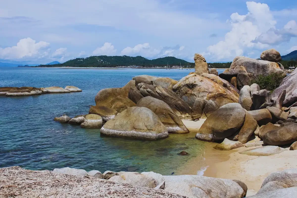 Hin Ta and Hin Yai Rocks along Koh Samui’s coastline with turquoise sea and mountain backdrop.