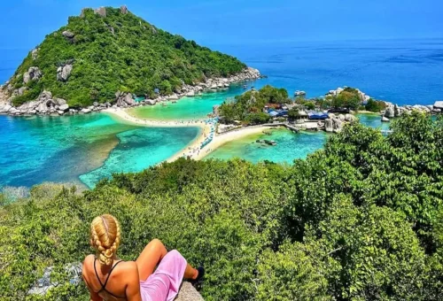 View from the top of Koh Nang Yuan showing sandbar beach, turquoise sea, and lush green hills near Koh Tao.