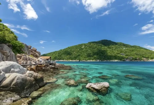 Wooden boardwalk along clear blue water and granite rocks at Koh Nangyuan viewpoint near Koh Tao.