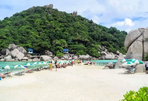 Tourists relaxing under beach umbrellas on Koh Nangyuan’s famous white sandbar.