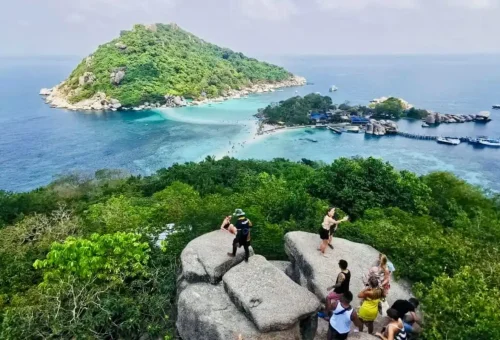 Group of visitors taking photos from the top viewpoint overlooking Koh Nangyuan’s sandbar and blue sea.