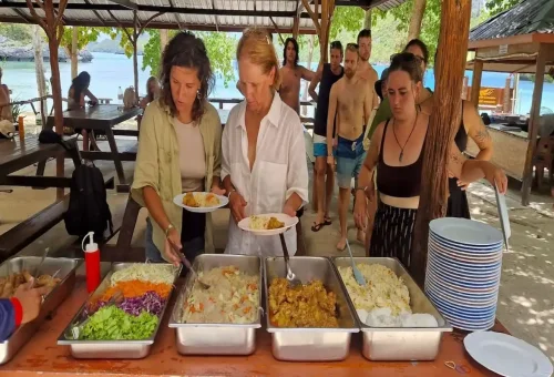 Tourists enjoying a buffet lunch with Thai food near the beach at Angthong Marine Park.
