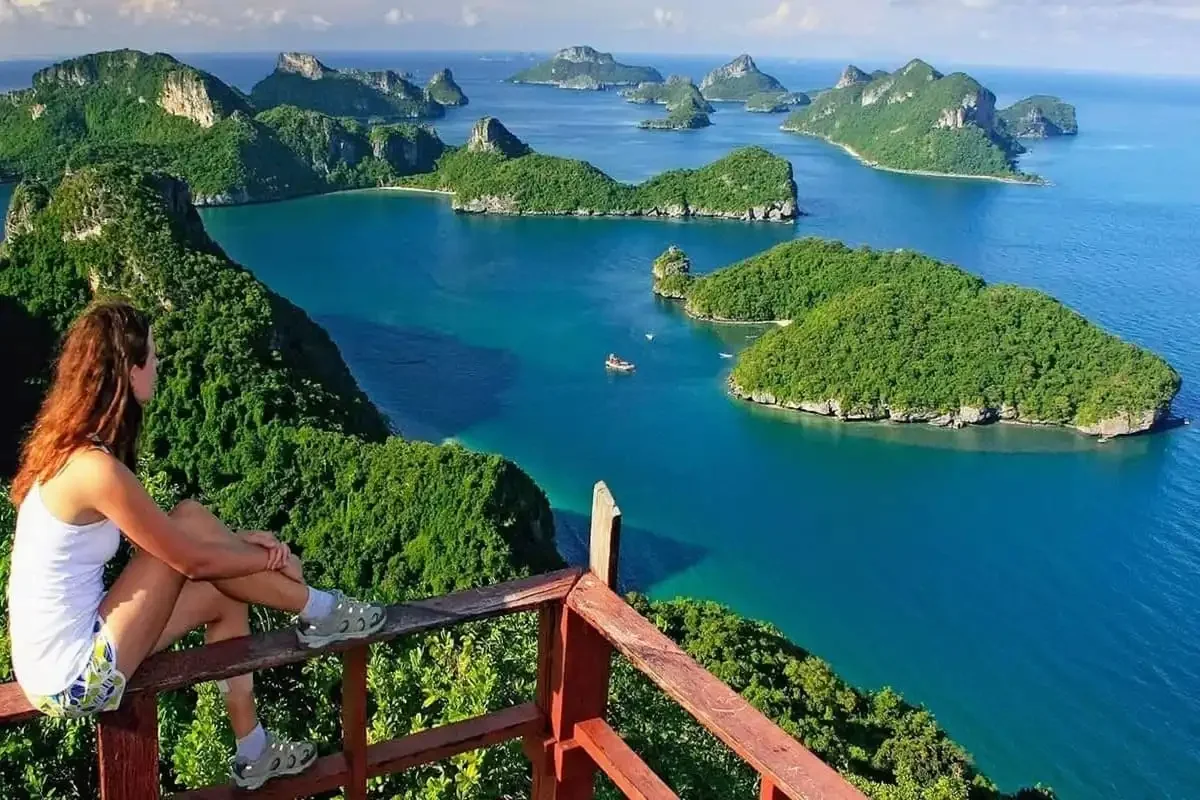 Traveler enjoying panoramic view of Angthong Marine Park islands from Koh Wua Talap viewpoint.