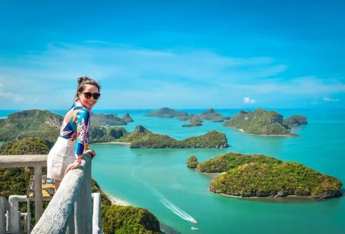 Smiling woman enjoying the panoramic island view at Angthong Marine Park viewpoint.