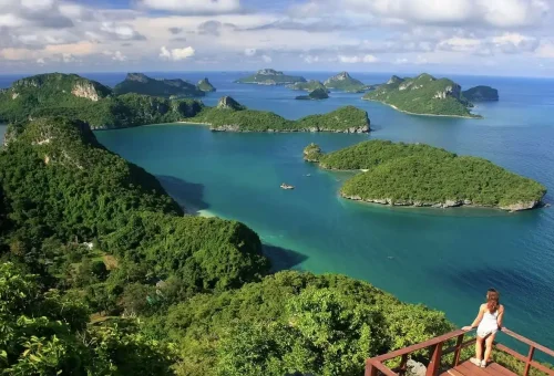 Traveler admiring panoramic view of the 42 islands of Angthong Marine Park from Koh Wua Talap viewpoint.